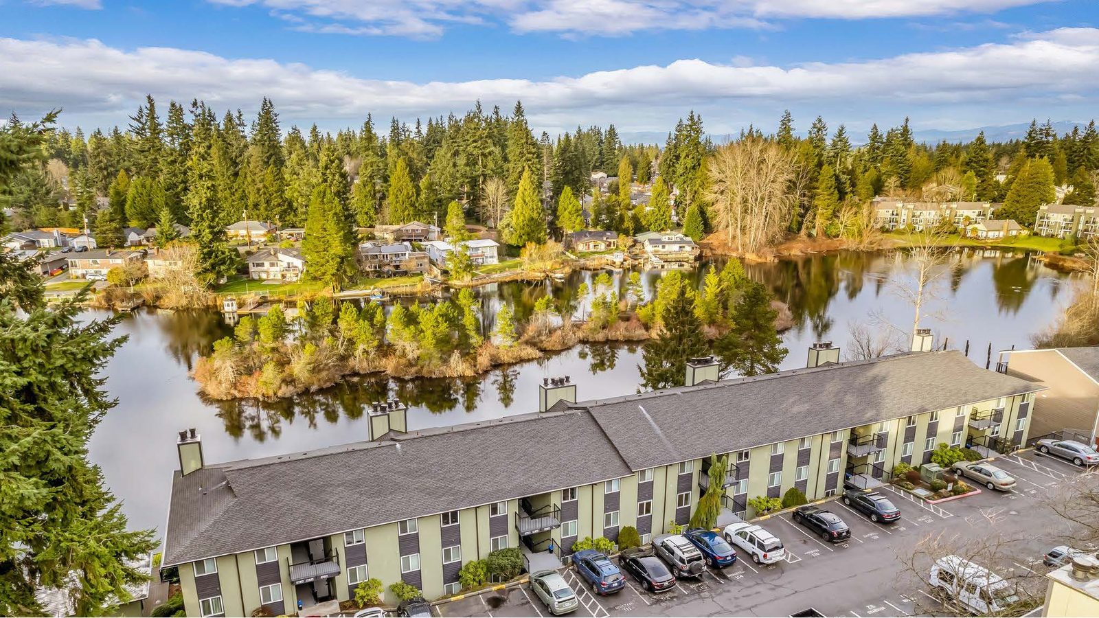 Aerial view of a lakeside condominium and townhome community managed by Quorum